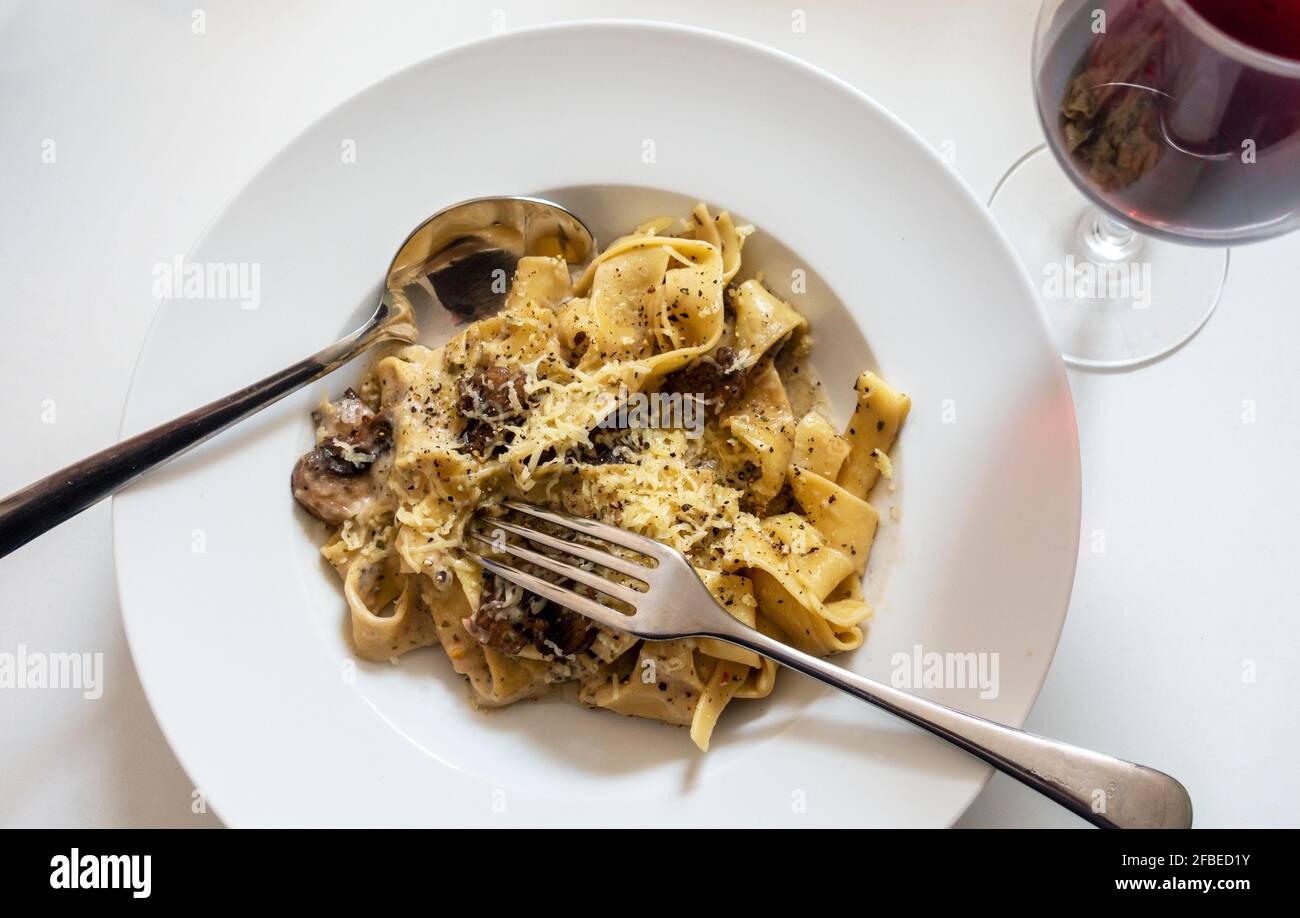 Pappardelle mit Pilzen und einem Glas Rotwein Stockfoto