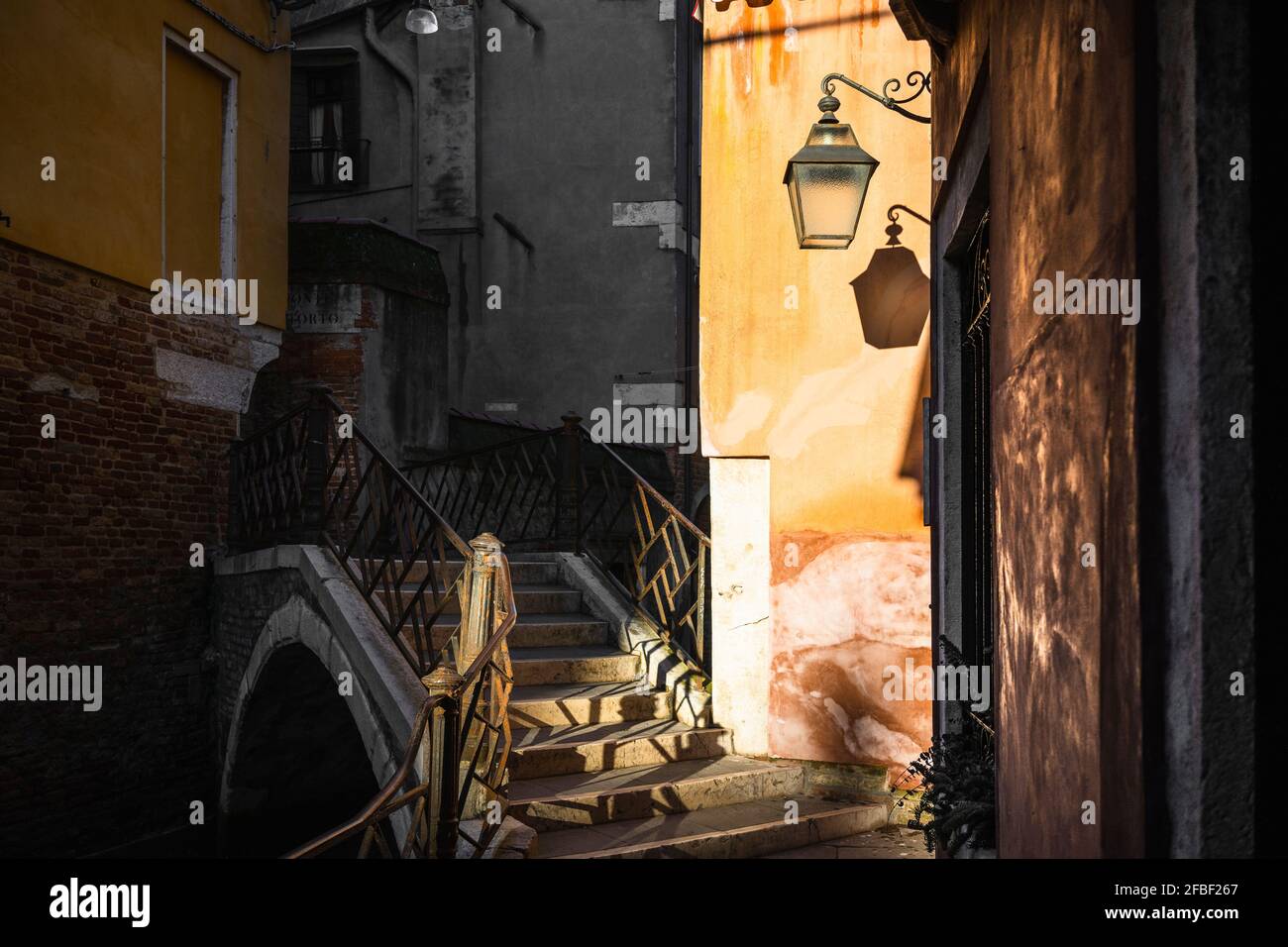 Italien, Venetien, Venedig, Alte Bogenbrücke über den engen Stadtkanal in der Abenddämmerung Stockfoto