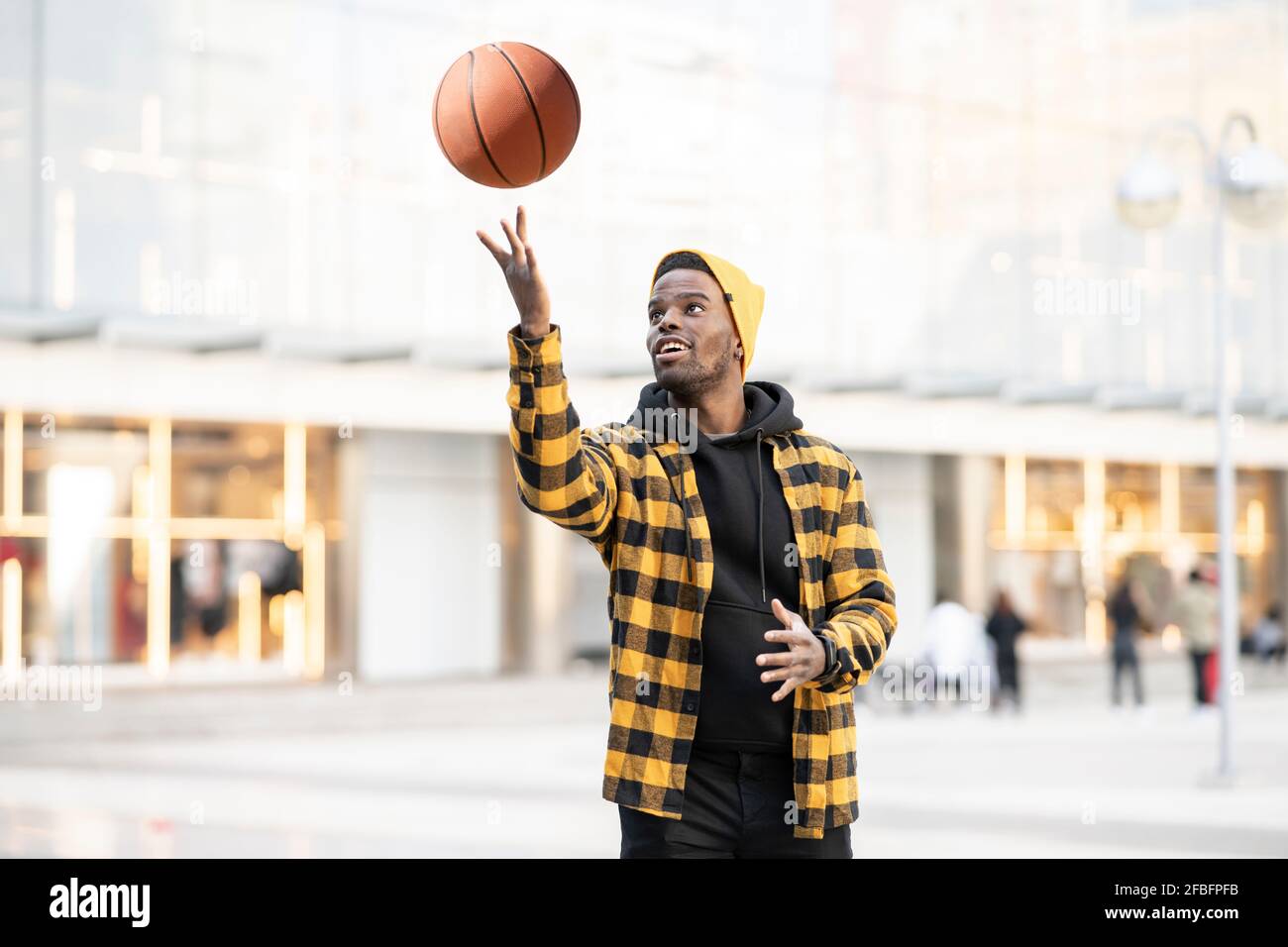 Junger Mann Spinnen Basketball am finger Stockfoto