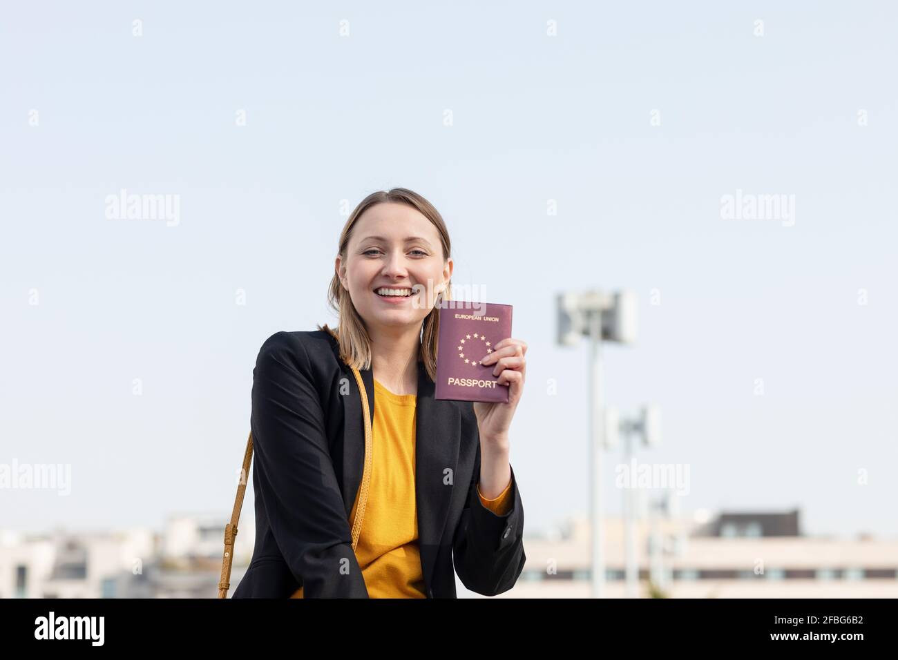 Fröhliche Geschäftsfrau, die ihren Pass zeigt Stockfoto