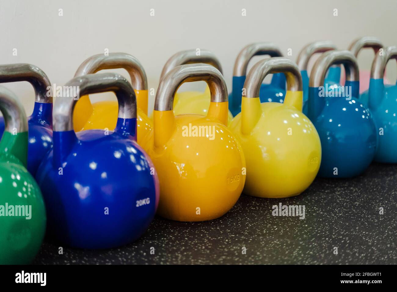 Mehrfarbige Kugelhantel in einer Linie im Fitnessstudio Stockfoto