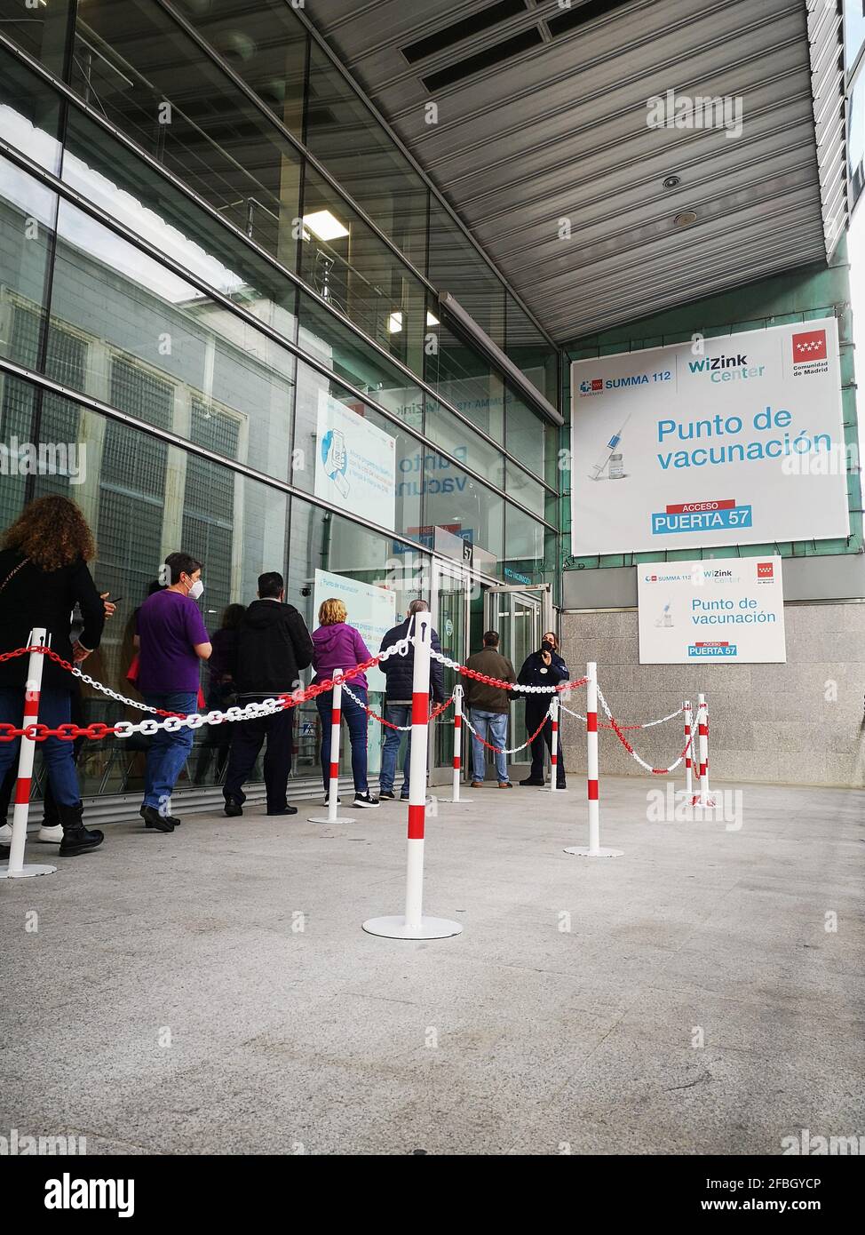 Madrid, Spanien. 23. April 2021: Erwachsene Patienten mit Gesichtsschutzmasken warten in der Schlange auf die Impfung gegen Covid-19 im WiZink-Zentrum Stockfoto