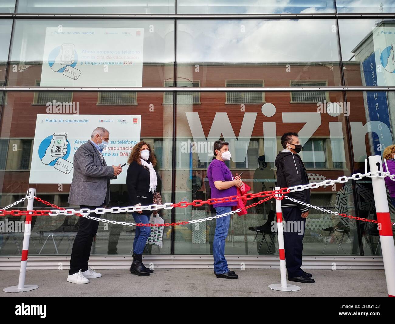Madrid, Spanien. 23. April 2021: Erwachsene Patienten mit Gesichtsschutzmasken warten in der Schlange auf die Impfung gegen Covid-19 im WiZink-Zentrum Stockfoto