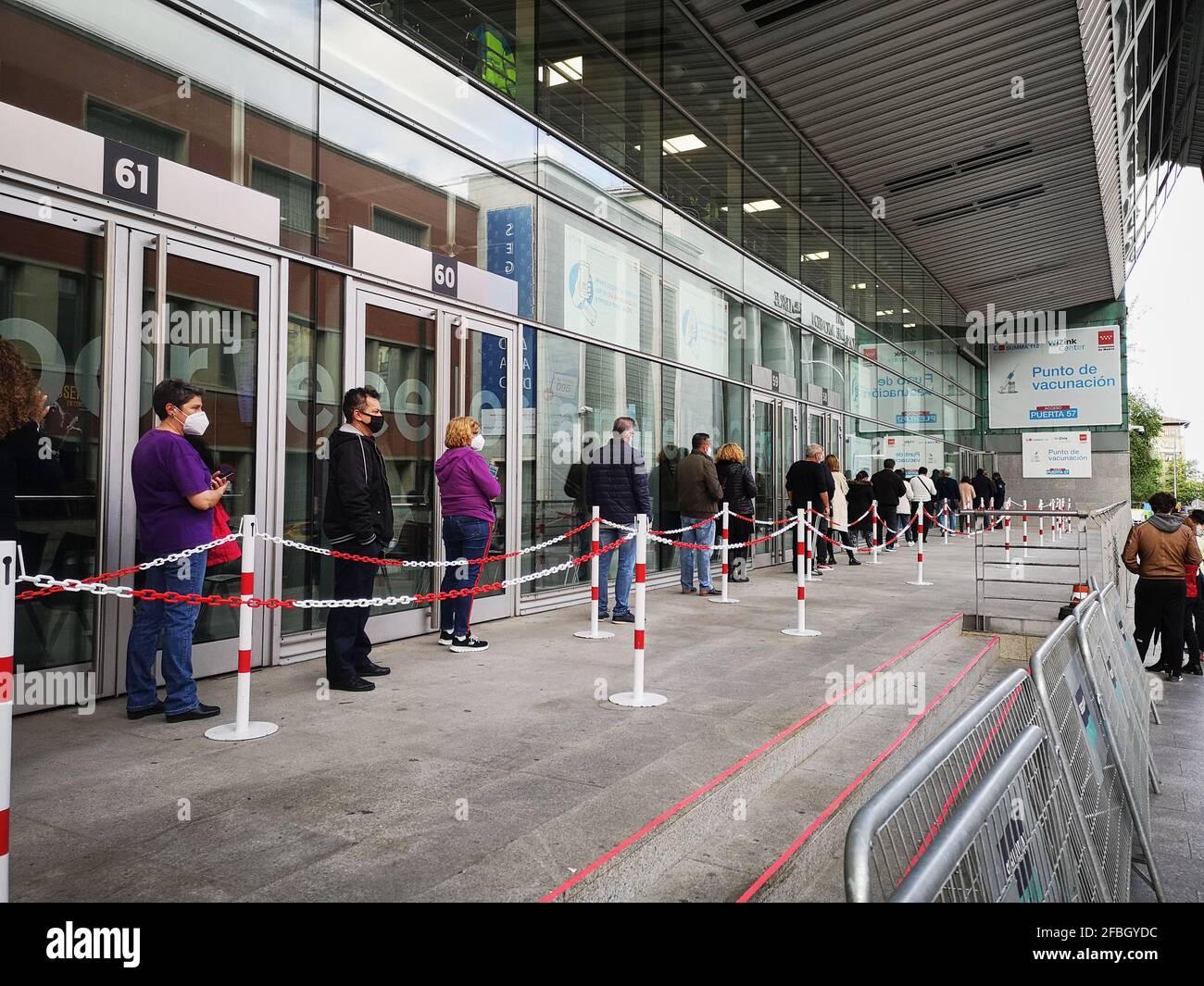 Madrid, Spanien. 23. April 2021: Erwachsene Patienten mit Gesichtsschutzmasken warten in der Schlange auf die Impfung gegen Covid-19 im WiZink-Zentrum Stockfoto