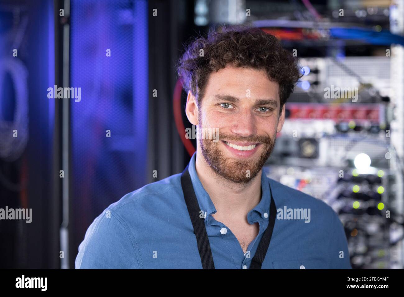 Glücklicher männlicher IT-Techniker, der im Rechenzentrum steht Stockfoto