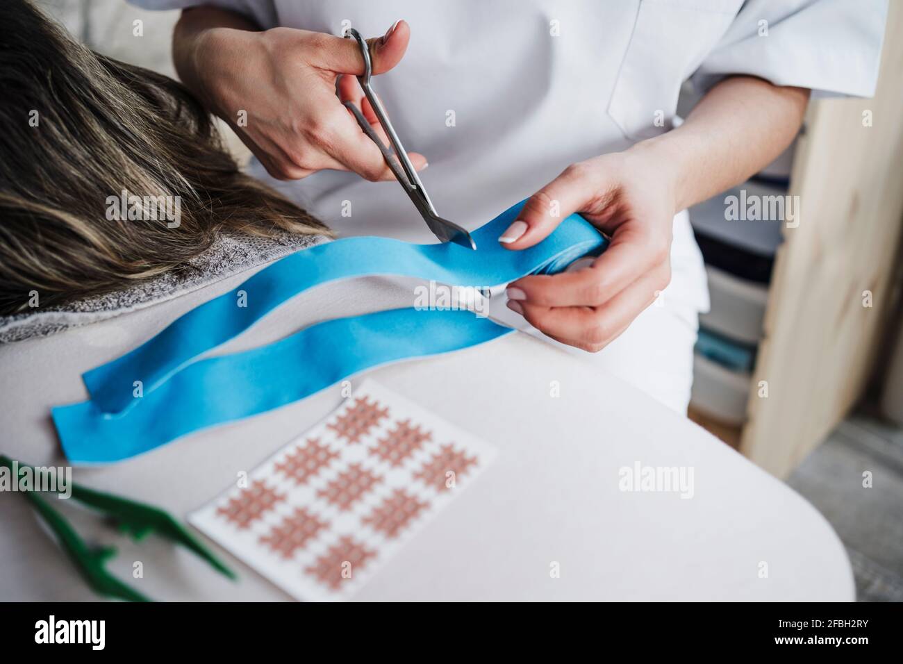 Physiotherapeutin schneidet elastisches therapeutisches Band Stockfoto