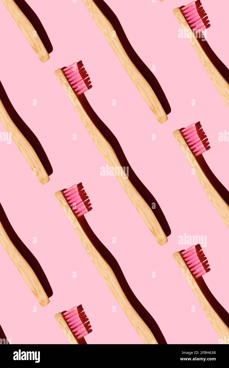 Digital generiertes Muster mit Bambuszahnbürsten auf rosa Hintergrund Stockfoto