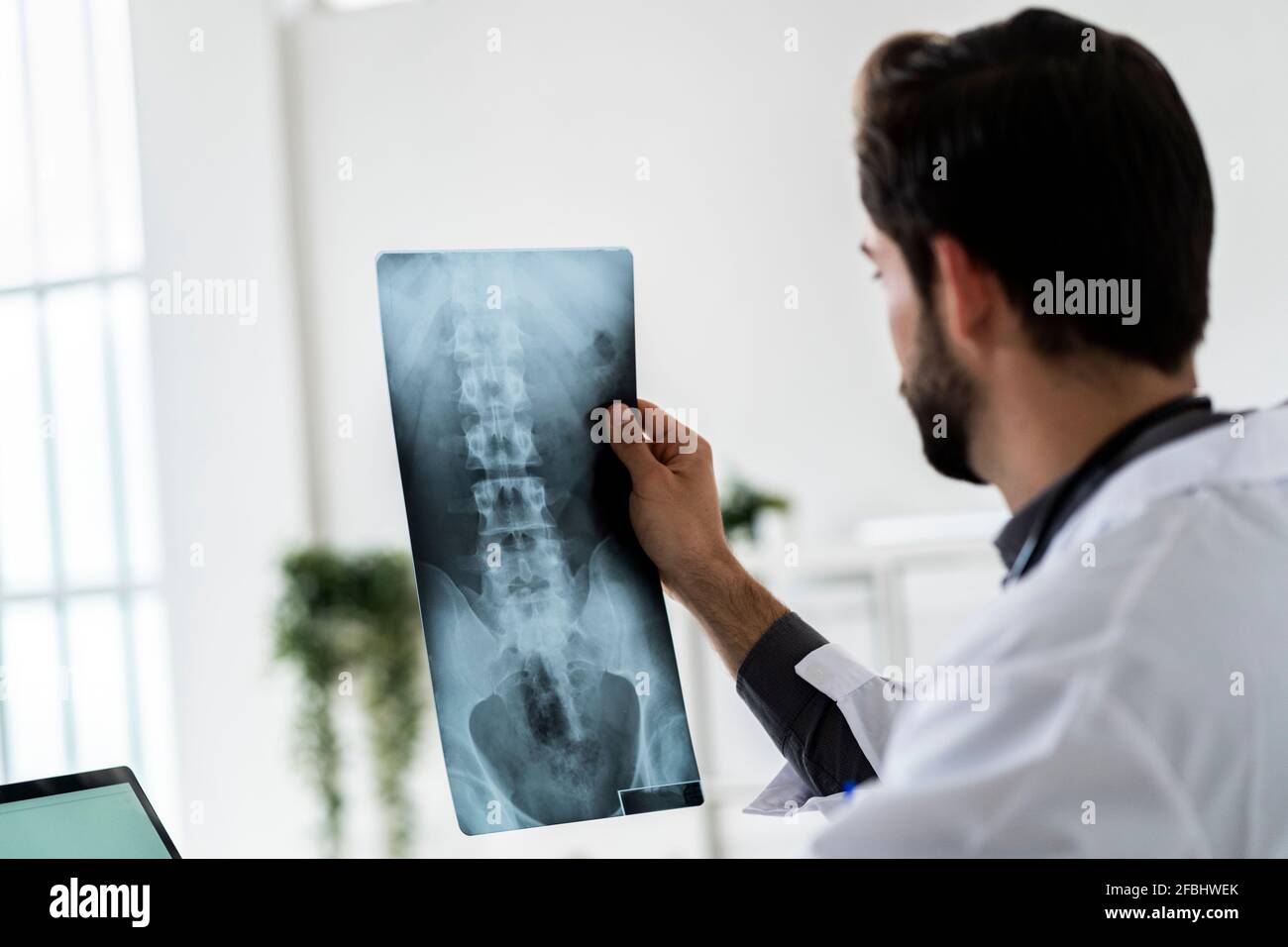 Männlicher Arzt, der Röntgenaufnahmen im Krankenhaus untersucht Stockfoto