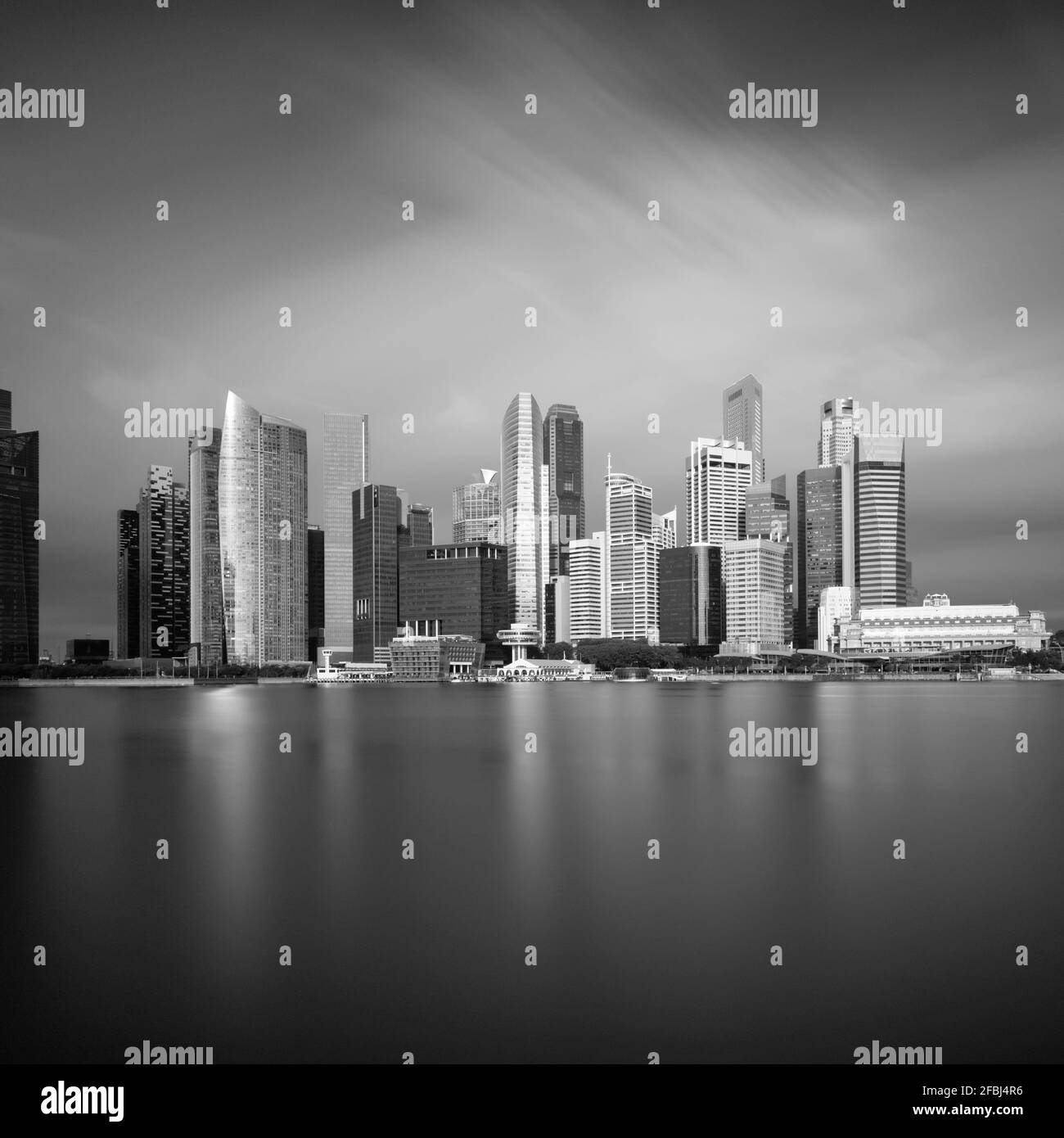 Singapur, lange Belichtung der Marina Bay mit Wolkenkratzern im Hintergrund Stockfoto