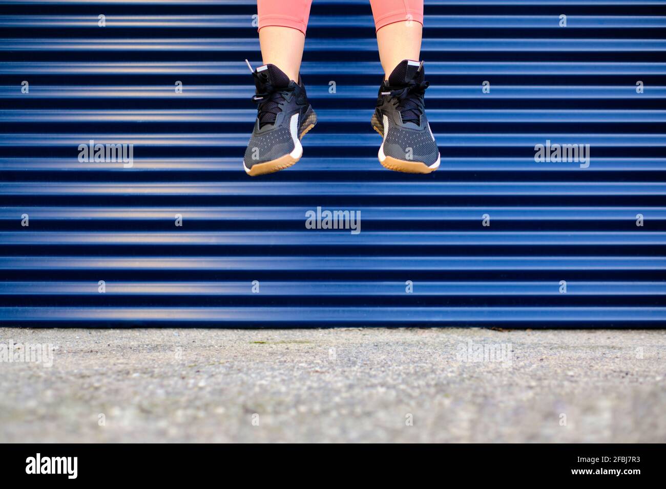 Sportlerin in der Luft über den Fußweg Stockfoto