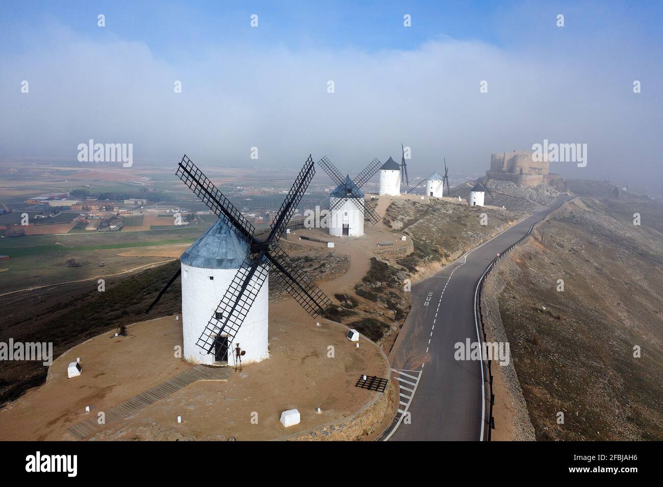 Spanien, Provinz Toledo, Consuegra, Luftaufnahme der Landstraße, die sich an historischen Windmühlen vorbeizieht Stockfoto