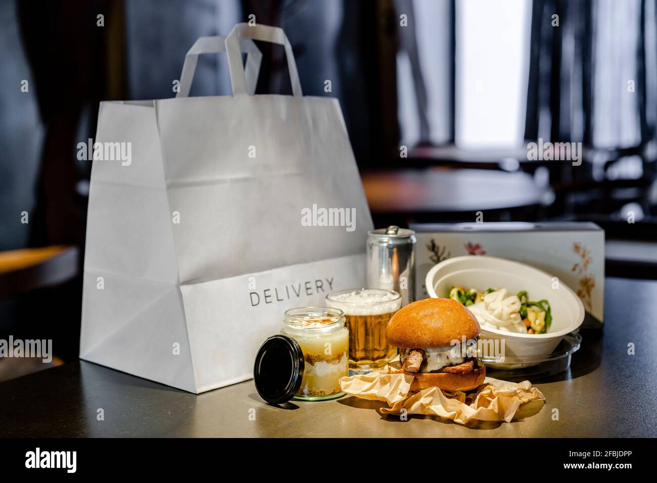 Essen mit Getränk, Dessert und Salat per Lieferbeutel und Box auf Kücheninsel Stockfoto