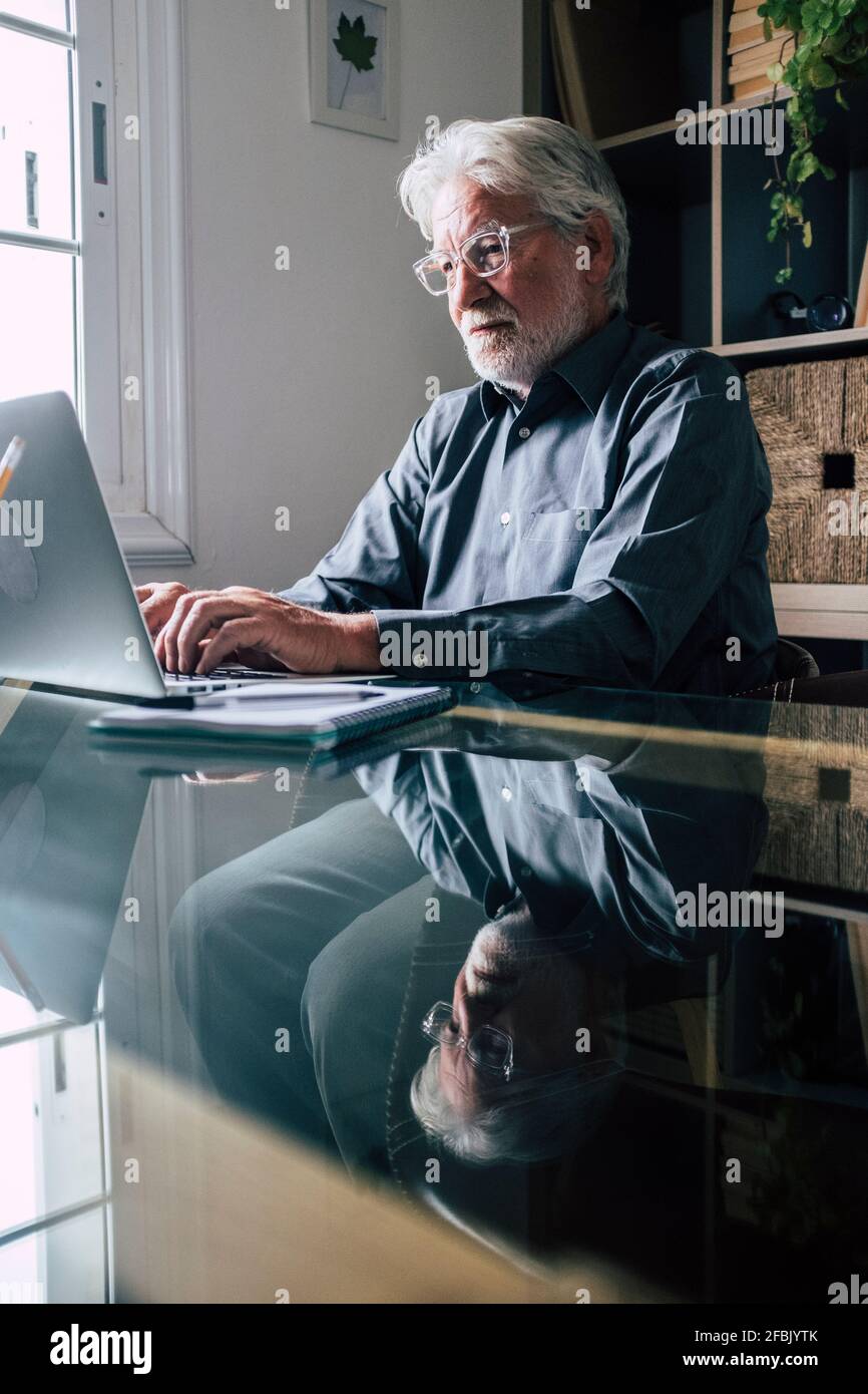 Leitender männlicher Profi mit Laptop, der von zu Hause aus arbeitet Stockfoto