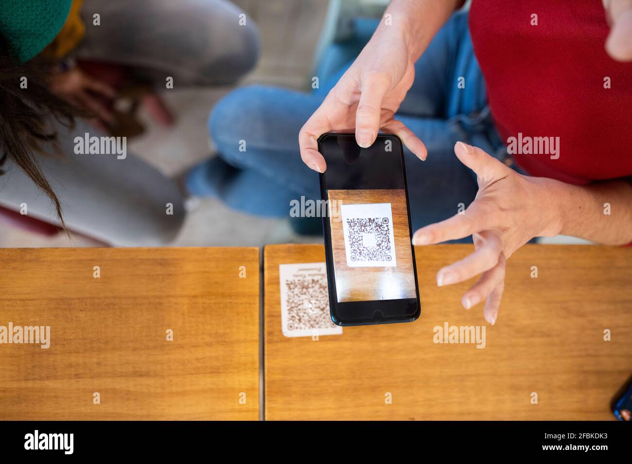 Frau scannt QR-Code über Smartphone im Café Stockfoto