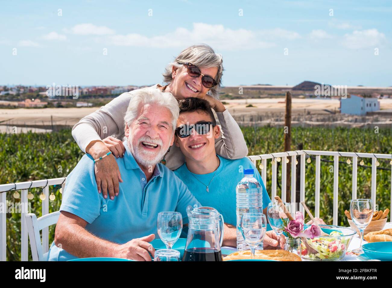 Lächelnder Junge, der sich mit den Großeltern während des Mittagessens amüsieren kann Stockfoto