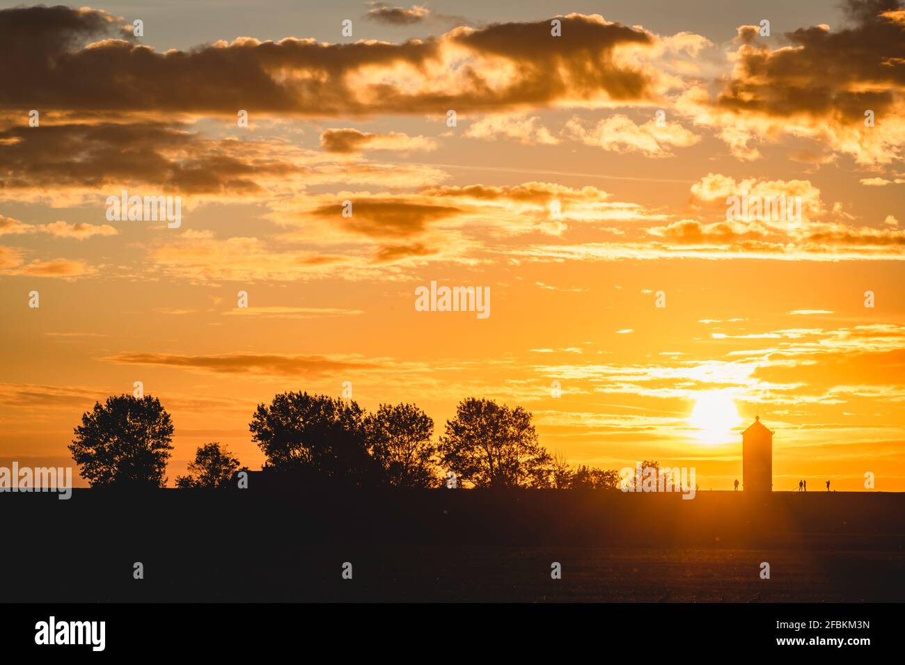 Deutschland, Niedersachsen, Krummhorn, Silhouette des Pilsum Leuchtturms bei stimmungsvollen Sonnenuntergängen Stockfoto