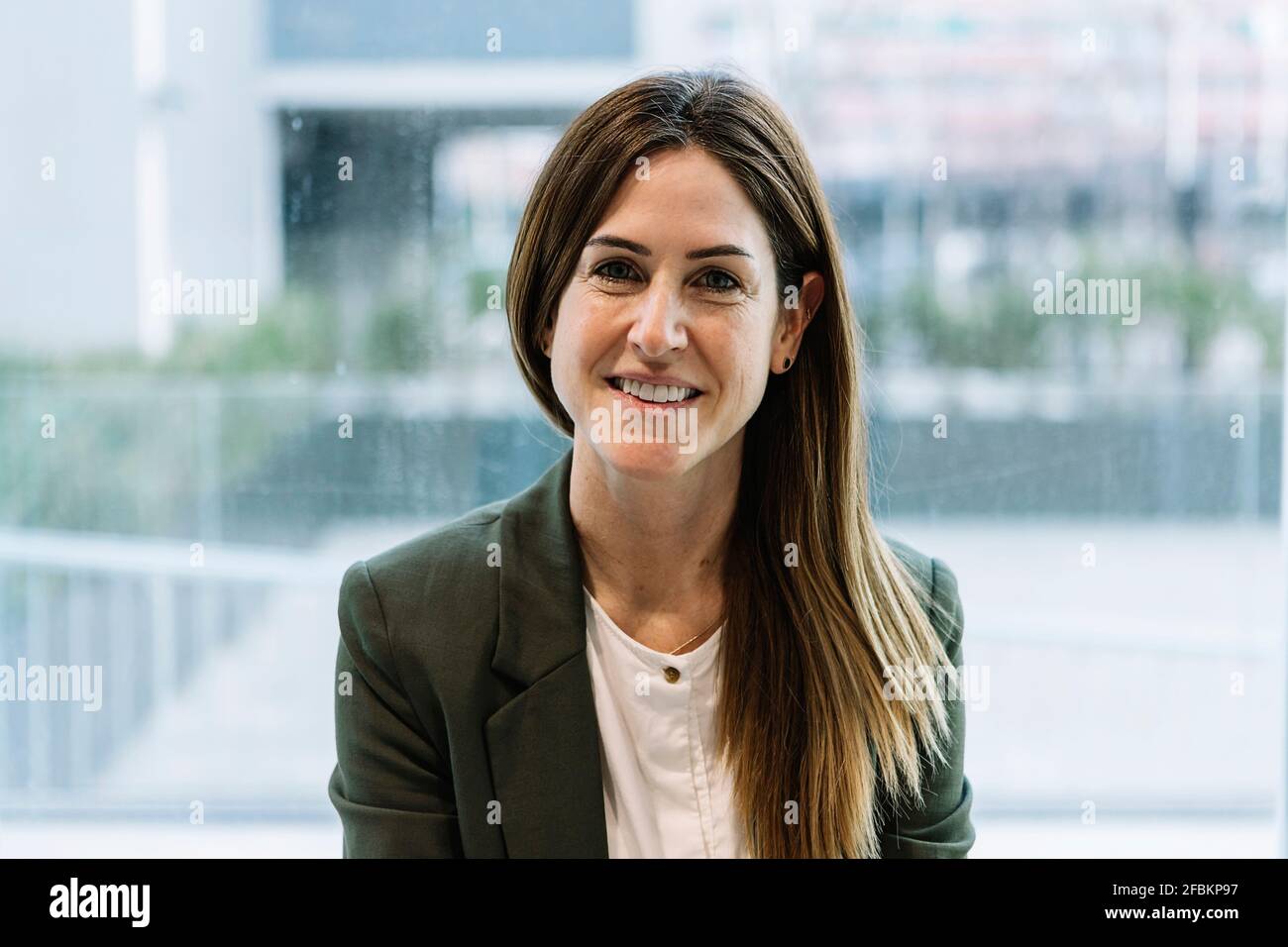 Geschäftsfrau in eleganter Casual an Glaswand im Büro Stockfoto