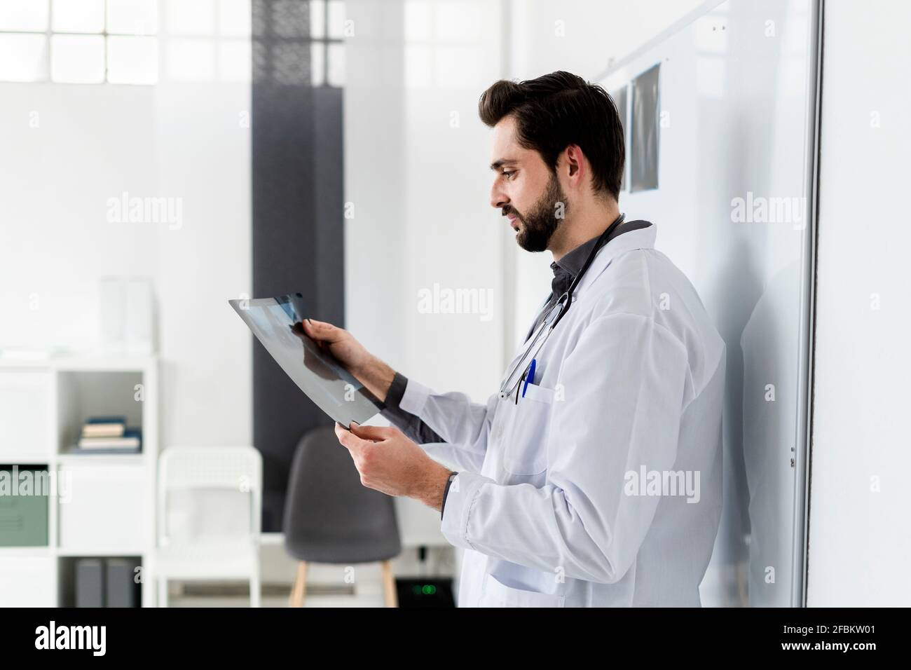 Männlicher medizinischer Experte untersucht Röntgenbericht im Krankenhaus Stockfoto