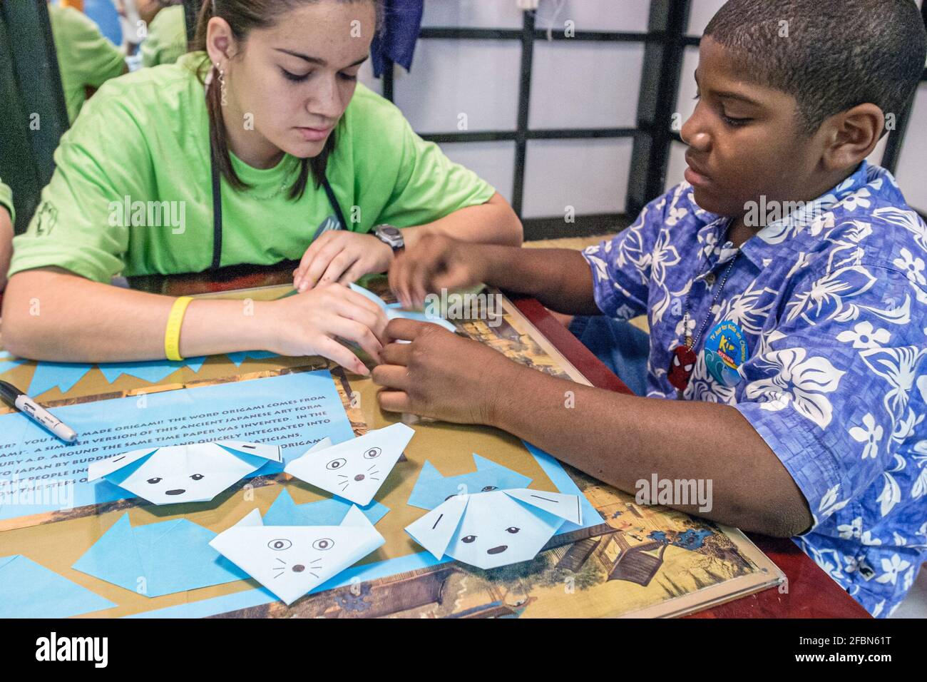 Miami Florida,Davie Young im Art Children's Museum,Festival of the Arts Schwarzer hispanischer Junge Teenager-Mädchen,Studenten lernen, wie man Origami macht, Stockfoto