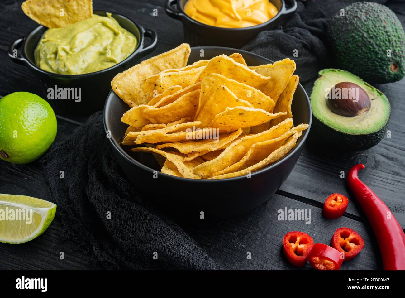 Verschiedene Dips und Saucen für Nacho, auf schwarzem Holzhintergrund Stockfoto