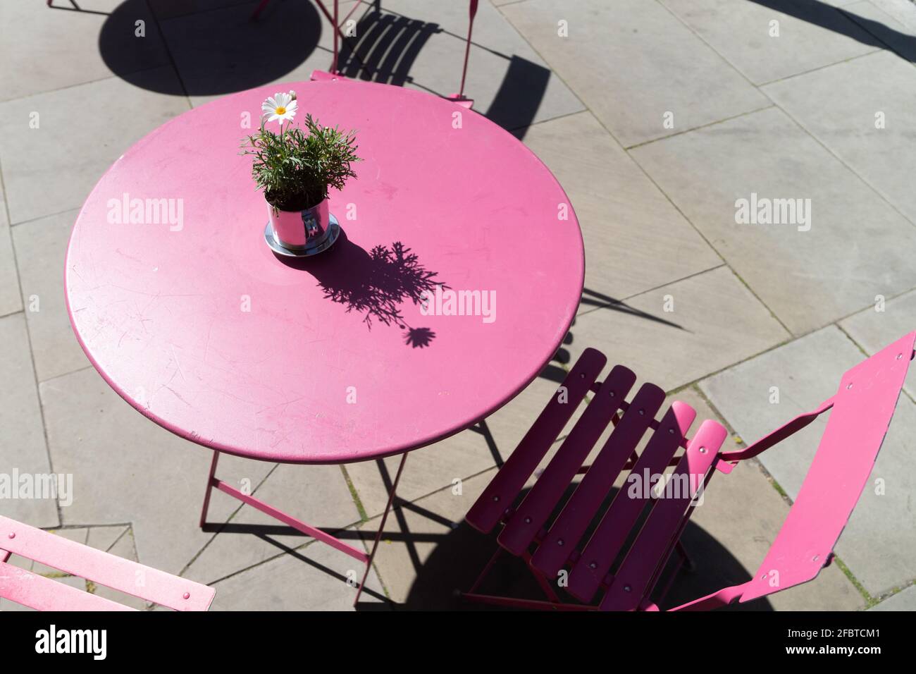 Es gab einen besseren rosafarbenen Tisch und Stühle auf der Bank Stockfoto