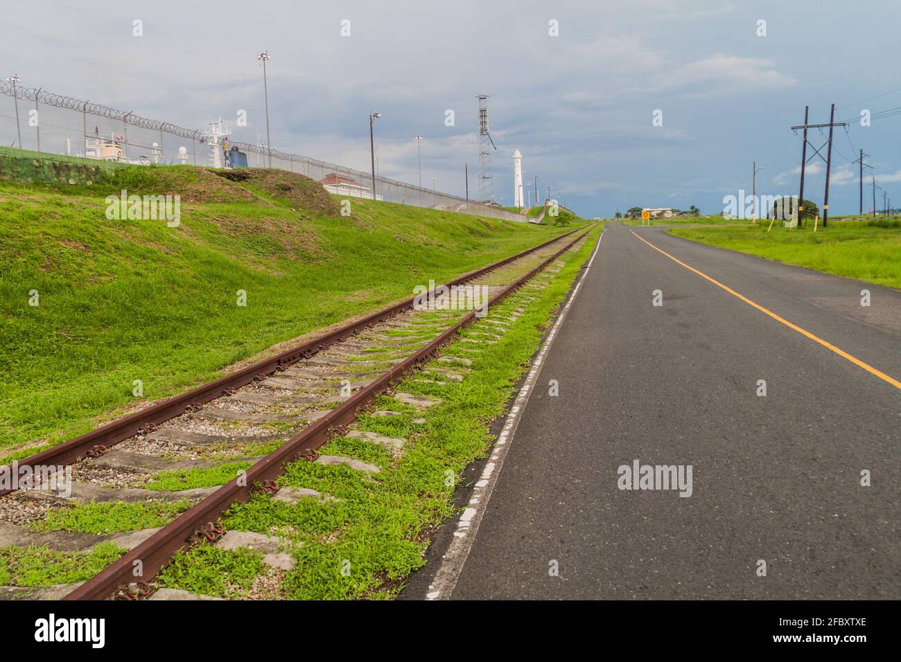 Straße und eine Eisenbahn, die an Gatun Locks, einem Teil des Panamakanals, vorbeiführt Stockfoto