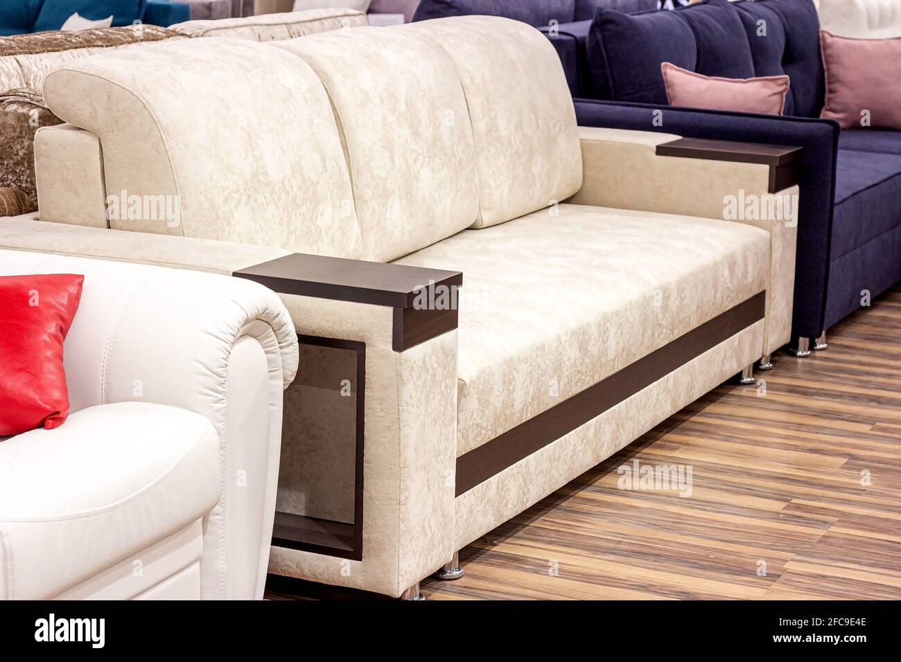 Großes, komfortables beigefarbenes Sofa im Luxusmöbelgeschäft. Stockfoto