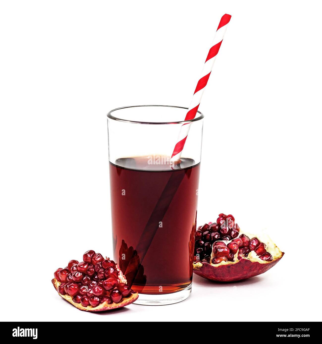 Frischer natürlicher Bio-roter Pomergranatsaft in einem Glas mit Granatstücken mit isolierten Samen auf weißem Hintergrund. Stockfoto