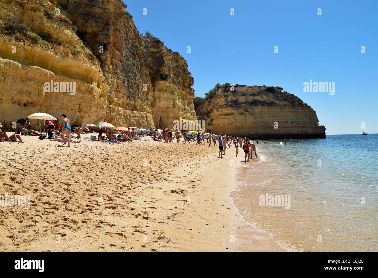 Leute, die den Strand von Praia da Marinha, Marinha Strand an der Algarve Portugal im Sommer genießen, mit wunderschönem Meer- und Bergblick Stockfoto