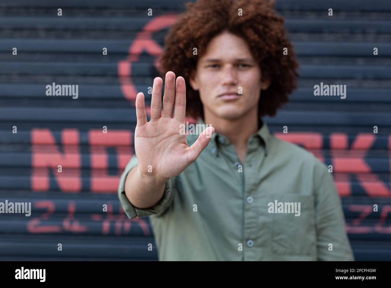 Porträt eines Mannes mit gemischter Rasse, der die Hand hält und einen Stopp einstellt Geste Stockfoto