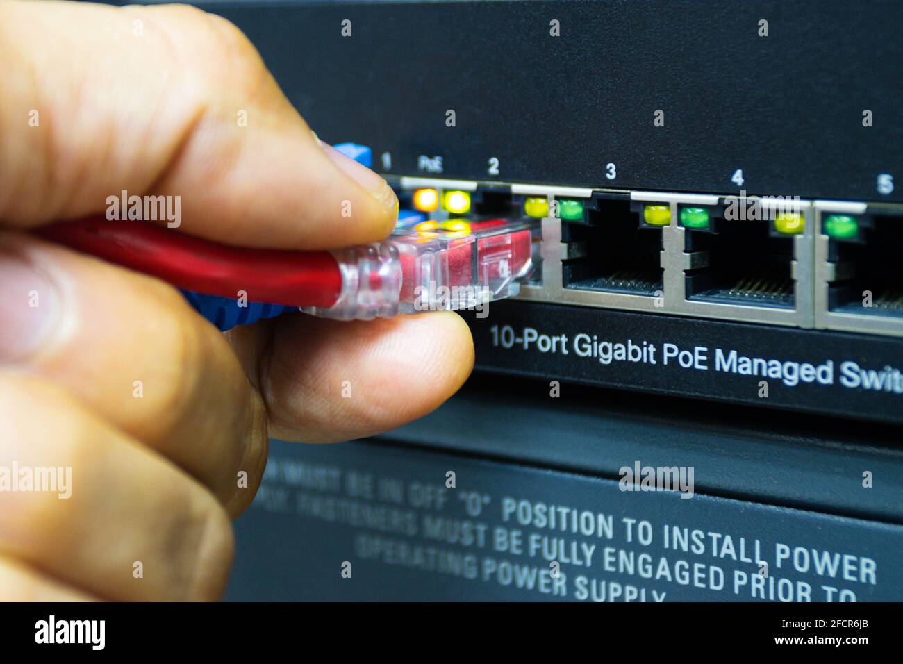 Techniker verbinden Kabel-Netzwerk zu Switch-Port im Serverraum , Konzept Internet-Netzwerk-Management Stockfoto