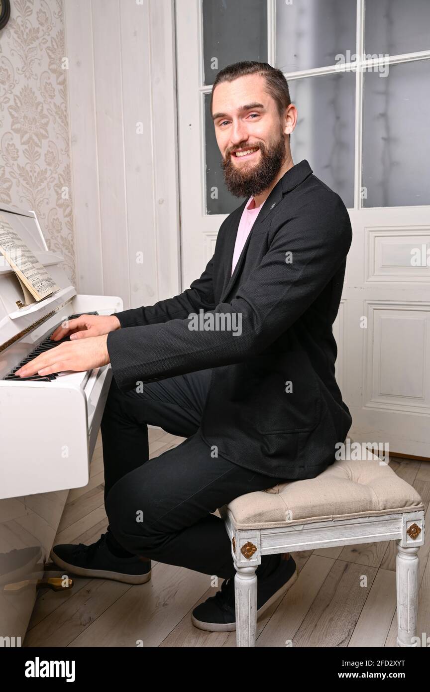 Ein junger, gut gekleideter Mann spielt Klavier. Stockfoto