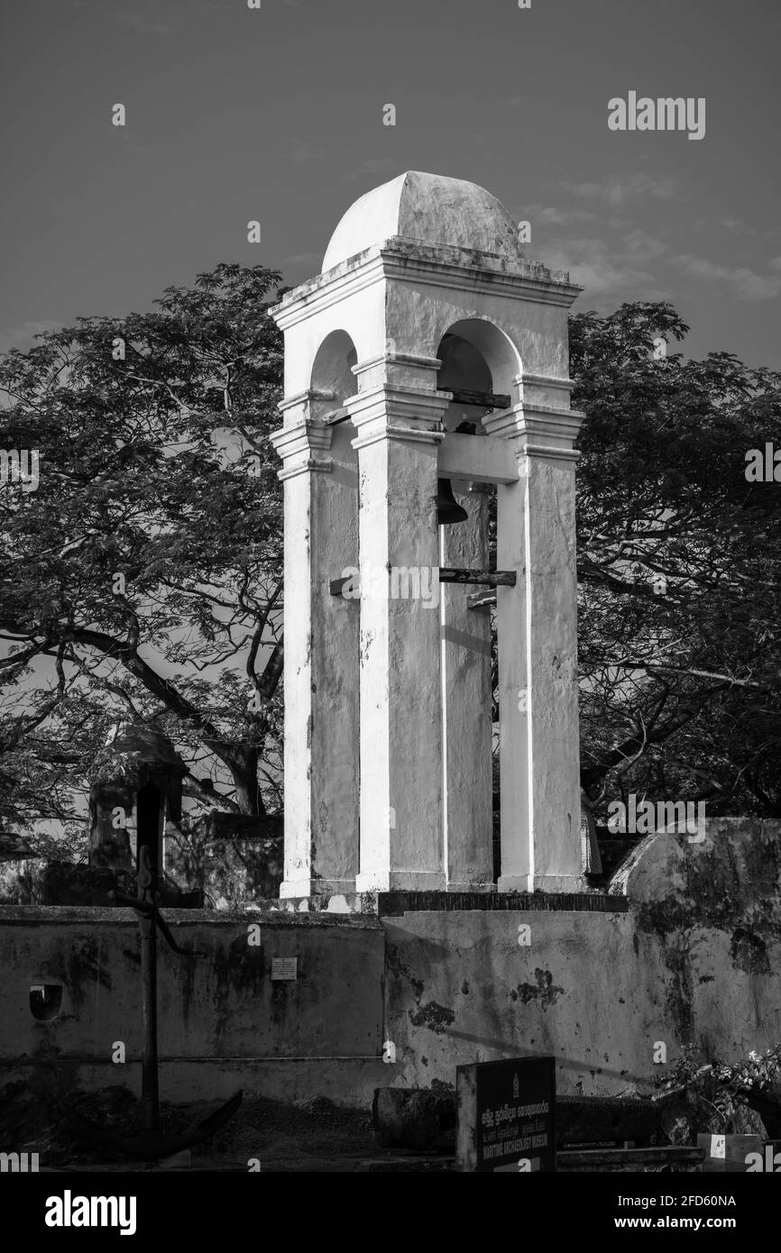 Hoher weißer Glockenturm im maritimen Museum in Galle Fort Schwarz-Weiß-Fotografie, abends helles Licht trifft die Seite des Turms. Stockfoto