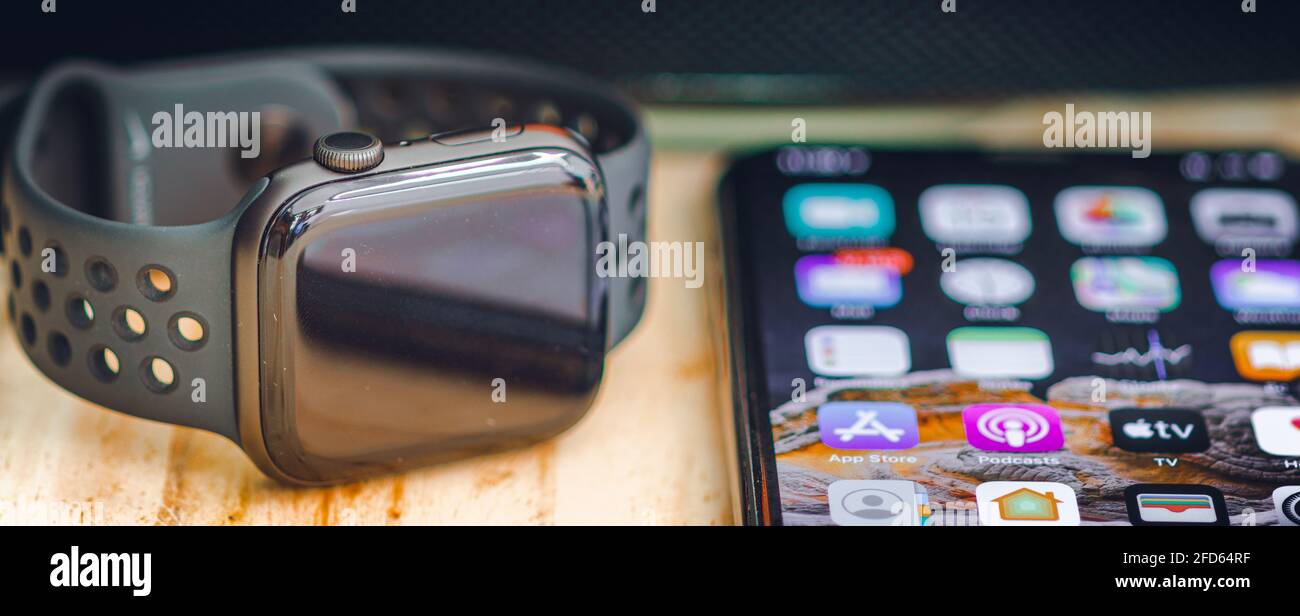 Die Apple I Uhren der Serie 6 und das iPhone 11 pro max liegen flach auf einem Holztisch, die Luxus-Smartwatch mit Touchscreen synchron Stockfoto