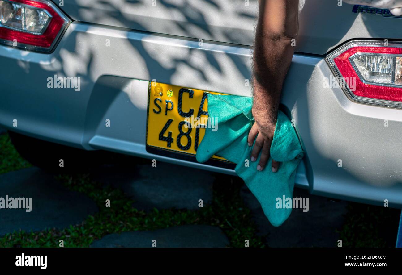 Austrocknen des Äußeren nach der Autowäsche, männlichen Händen und sauberem Fasertuch. Stockfoto