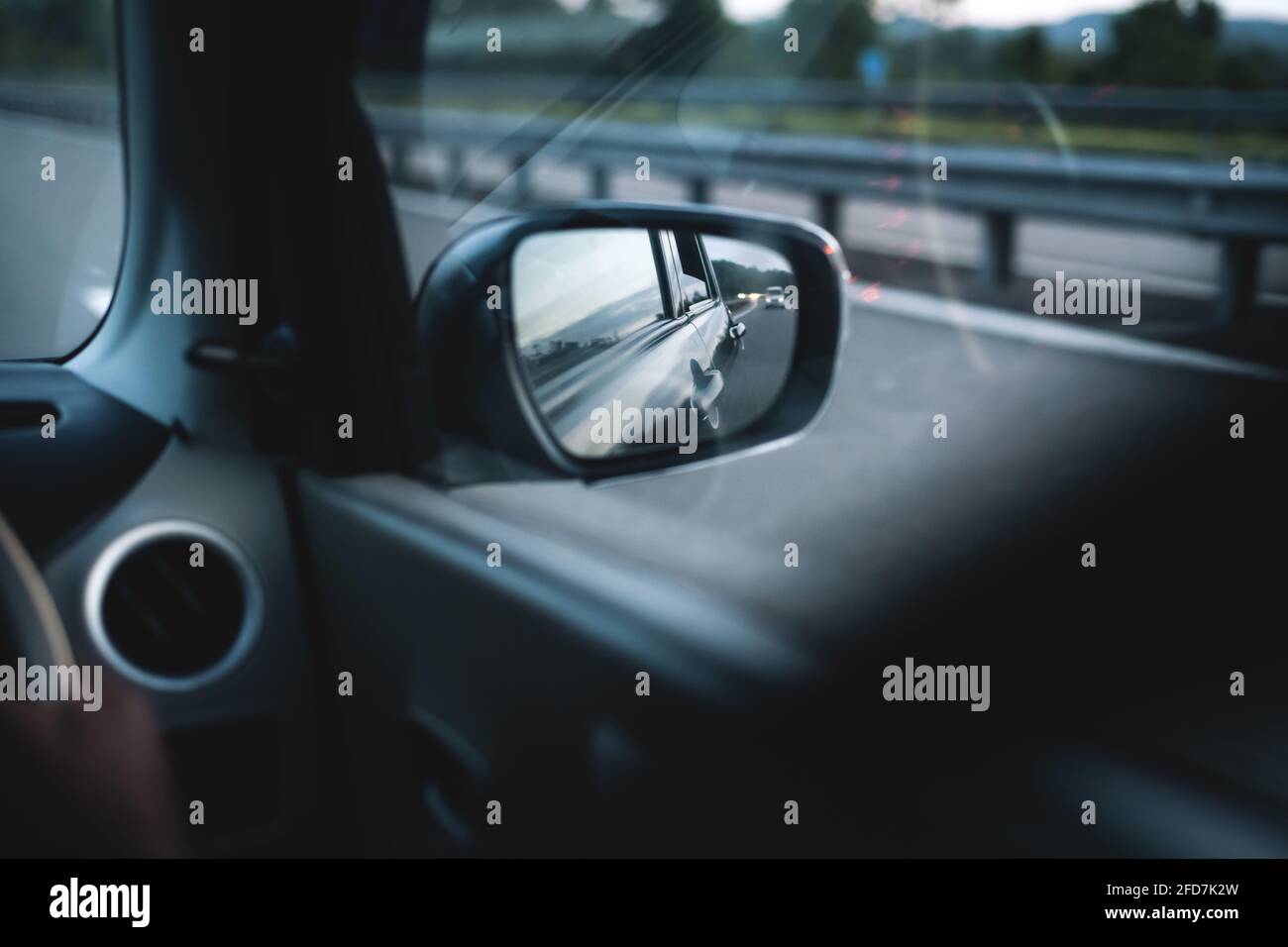 Auto-Seitenspiegel und die reflektierende Abendsonne von der Karosserie und  glühende in der Autobahn. Schnell bewegende Automobil-Konzept. Seite  Spiegel Sicht von Stockfotografie - Alamy