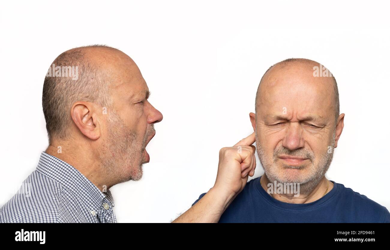 Ein Mann, der im Ohr schreit. Konzept seines Egos, das in sich selbst schreit Stockfoto