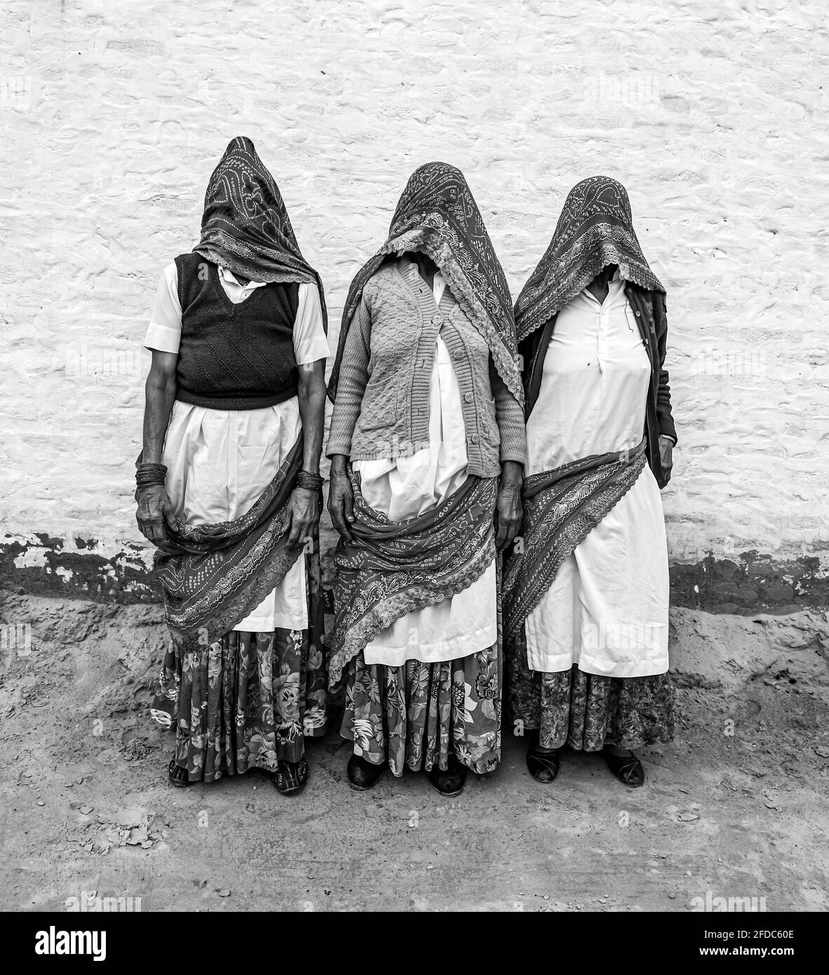 Schwarz-weißes Porträt einer älteren indischen Frau, die ihr Gesicht mit traditioneller Kleidung bedeckt. Stockfoto