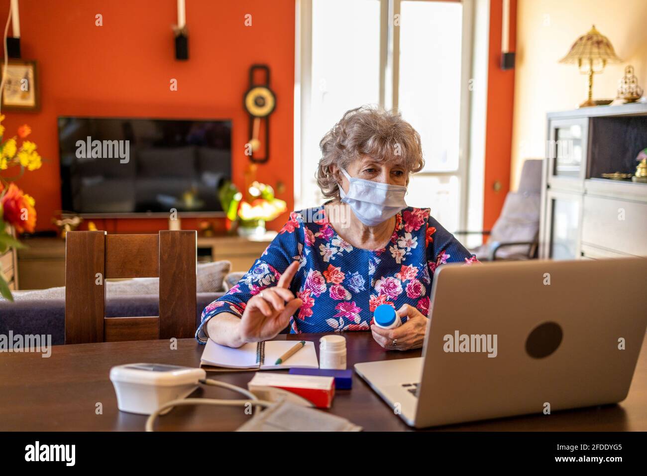 Eine ältere Frau, die sich mit einem Arzt auf ihrem Laptop besprache Stockfoto