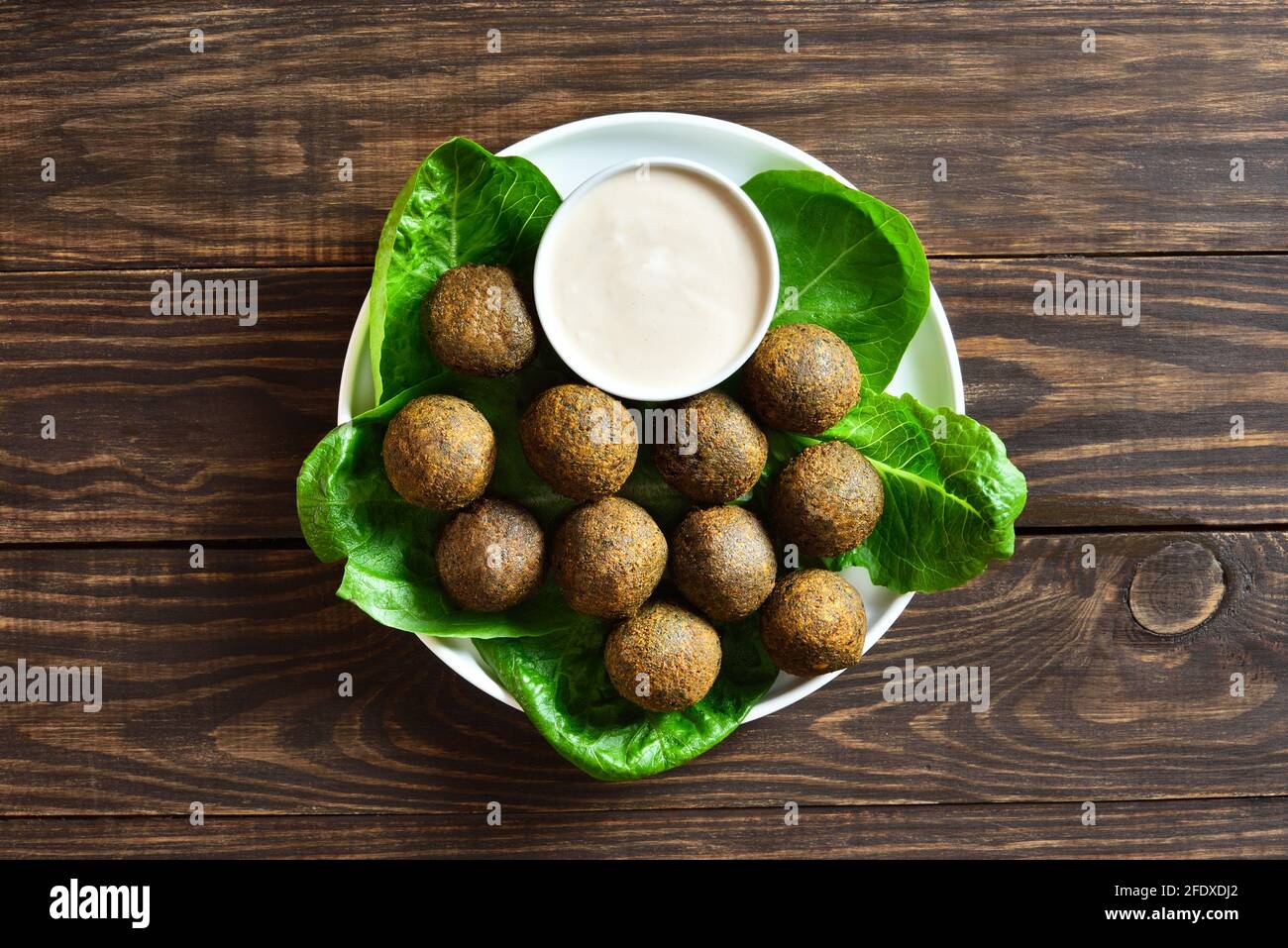 Falafel-Kugeln. Frittierte Kugeln aus gemahlenen Kichererbsen. Traditionelle Gerichte aus dem Nahen Osten. Holzhintergrund, Draufsicht, flach liegend, Nahaufnahme Stockfoto