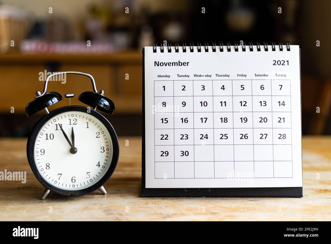 November 2021 Kalender - Monatsseite mit Datum und Jahrgang Uhr auf Holztisch Stockfoto