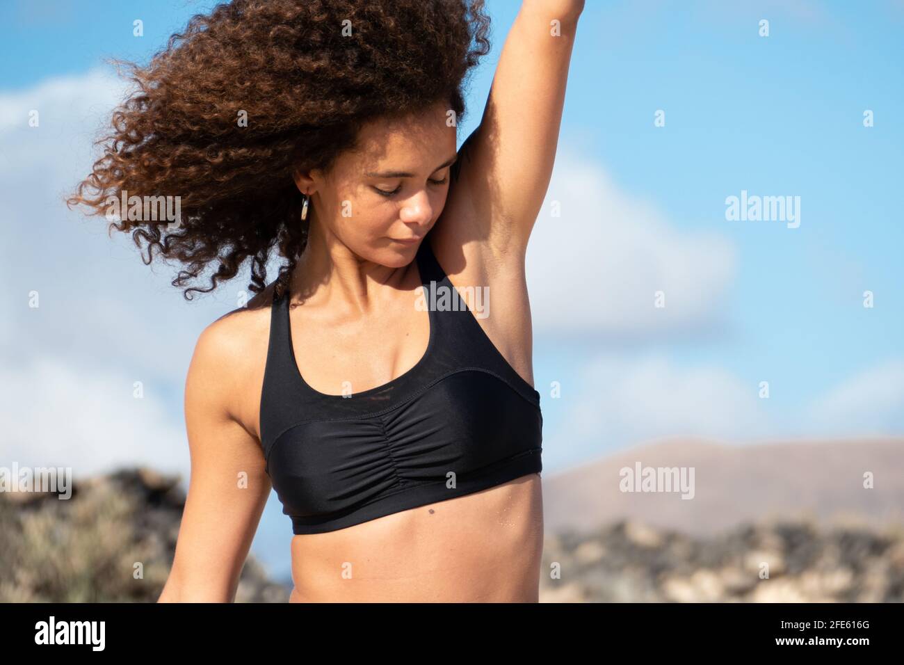 Afro junge Frau Porträt im Freien trägt Sportkleidung mit einem Arm mit Achselhöhlen angehoben Stockfoto