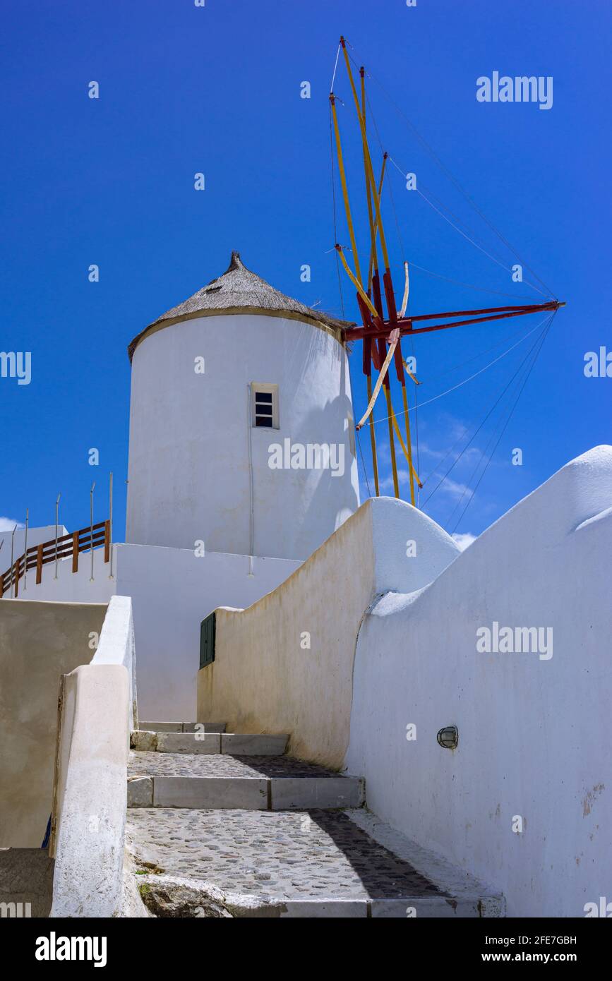 Eine Windmühle in Oia auf der griechischen Insel Santorini Griechenland an einem sonnigen Tag mit tiefblauem Himmel. Stockfoto