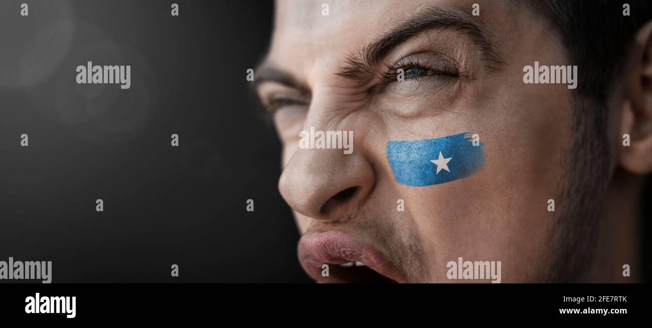 Ein schreiender Mann mit dem Bild des Somalia-Nationales Flagge auf seinem Gesicht Stockfoto