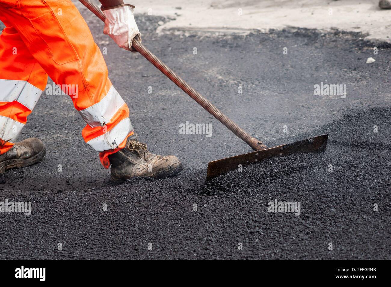 Mann bei der Arbeit während des Tarrings der Stadtstraßen Stockfoto