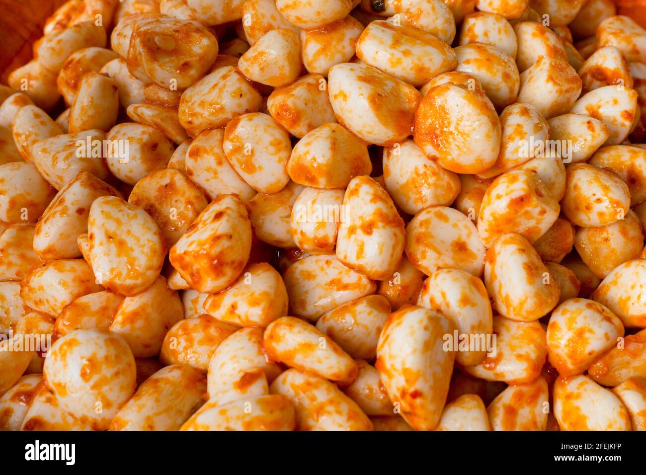 Schüssel mit frisch geschältem Knoblauch mit Tomaten- und Chilisauce Stockfoto