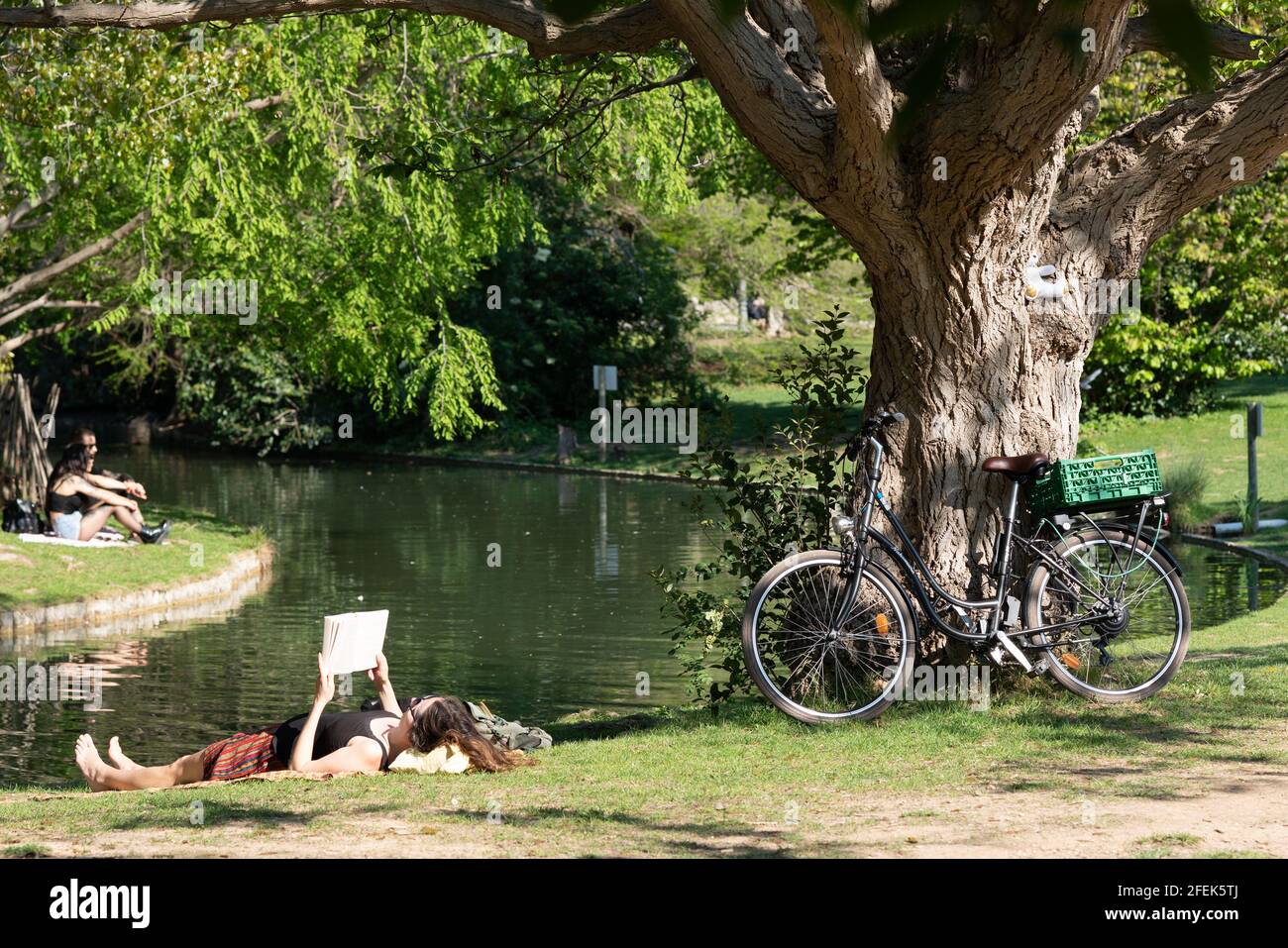 Junge Frau, die sich an einem sonnigen Frühlingstag im Park entspannt Stockfoto