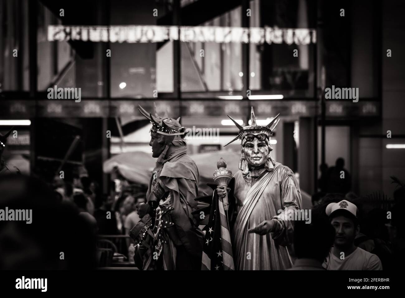 Schwarz-Weiß-Bild von zwei Männern, die in der Statue auftreten Freiheitskostüm am Times Square Stockfoto