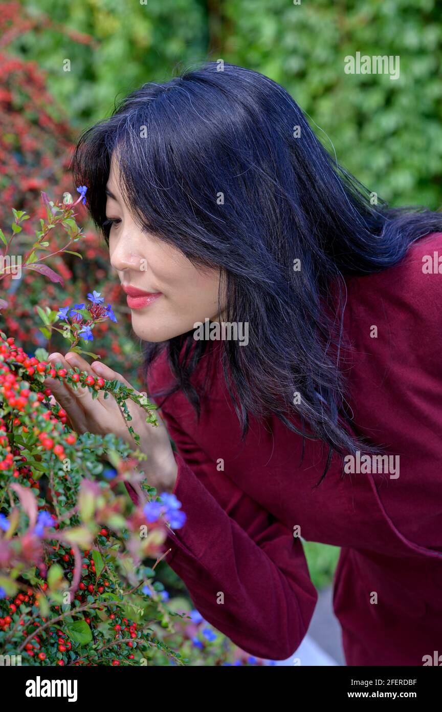 Schöne chinesische Frau mit langen schwarzen Haaren an einem sonnigen Herbsttag in der Stadt. Stockfoto