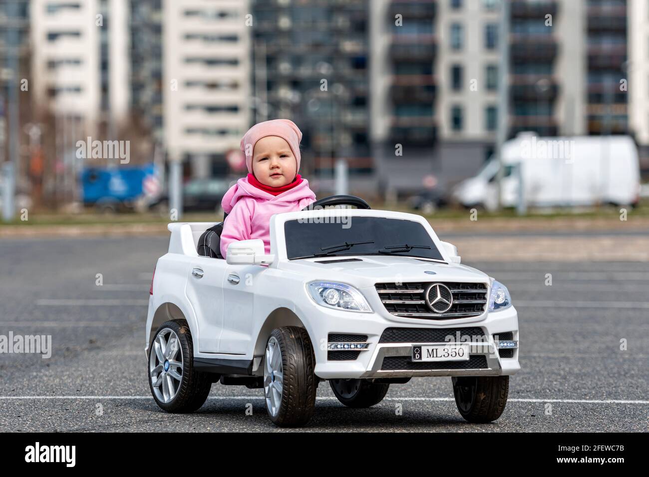 Kleine Girldriving ein Spielzeugauto. Kleiner Fahrer, Kinderwagen, Konzept der Verkehrssicherheit, Kinder im Auto Stockfoto